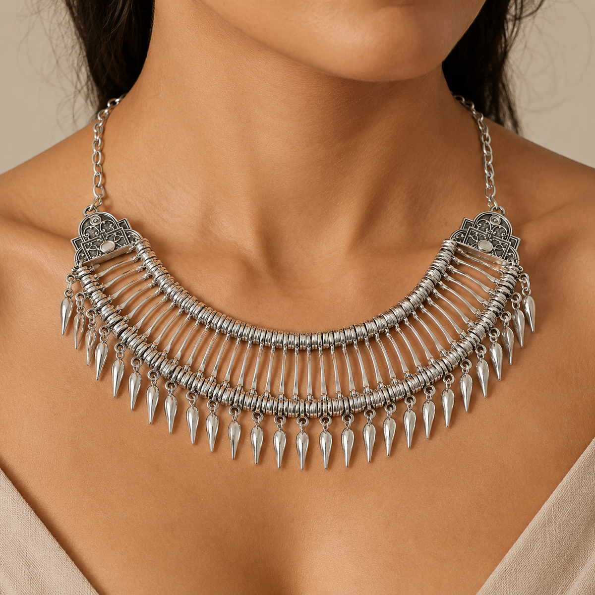 Silver-tone collar necklace with fan-like layers and teardrop dangles.
