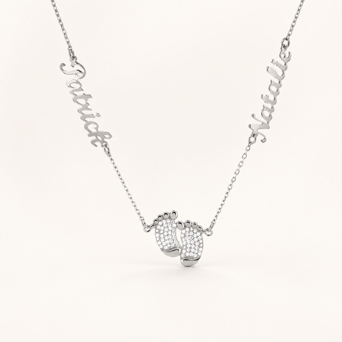 Silver-tone necklace with a baby feet pendant and two engraved names.