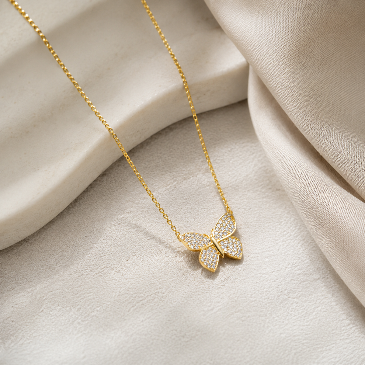 Angle view of a butterfly pendant necklace with sparkling accents.