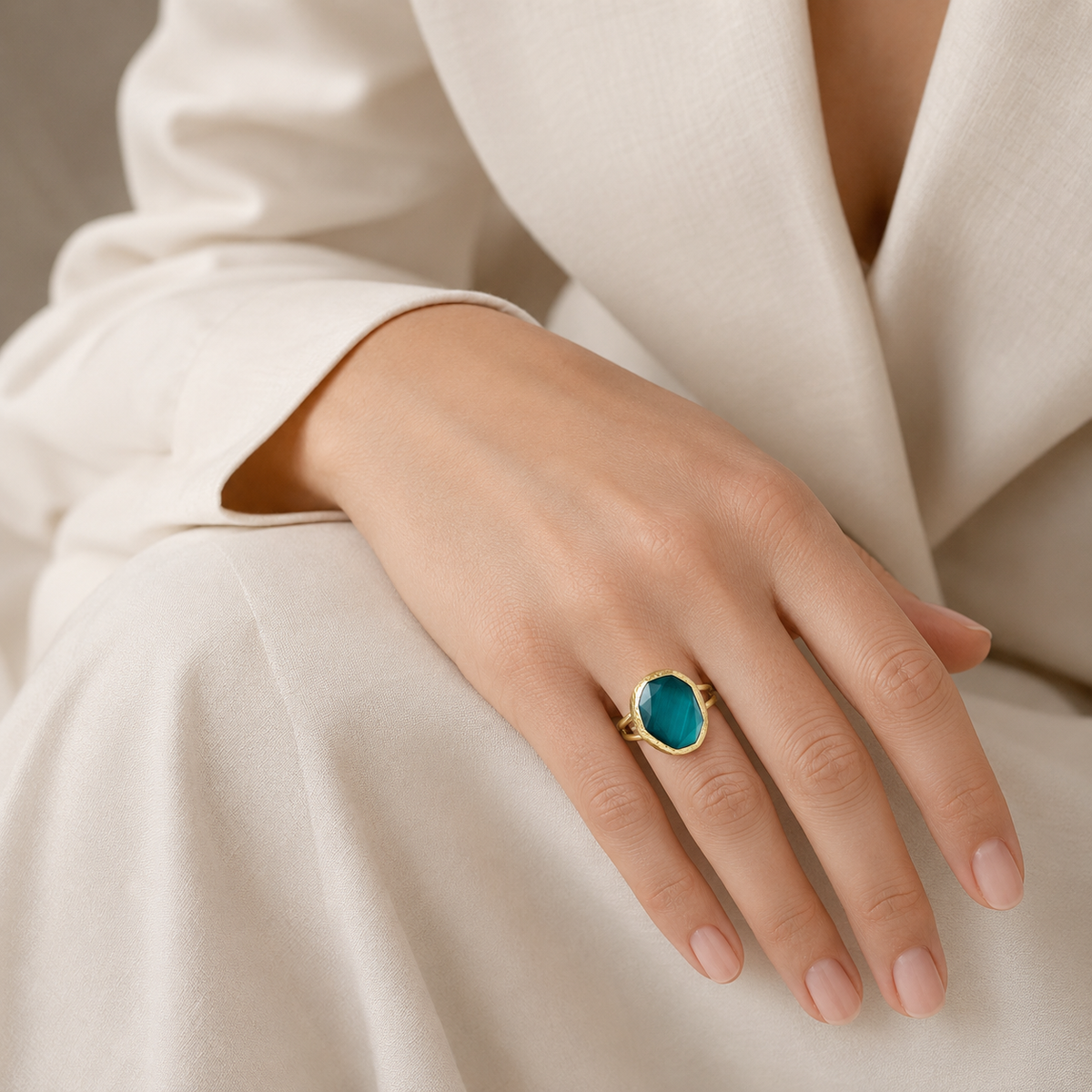 Gold-tone ring featuring a faceted green cat eye stone.