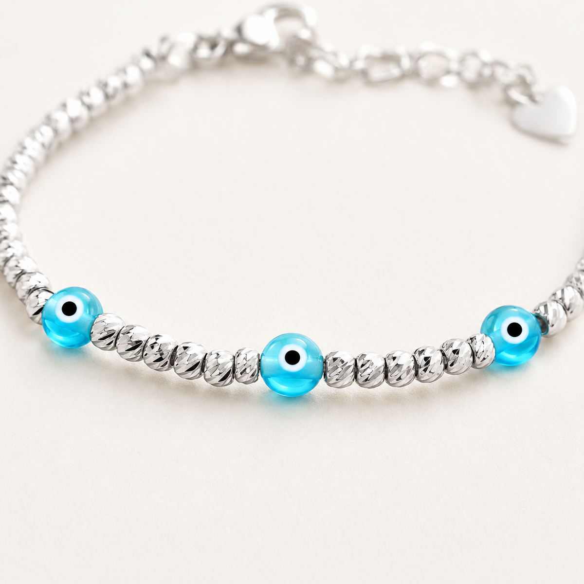Close view of the silver beaded bracelet and blue evil eye details.