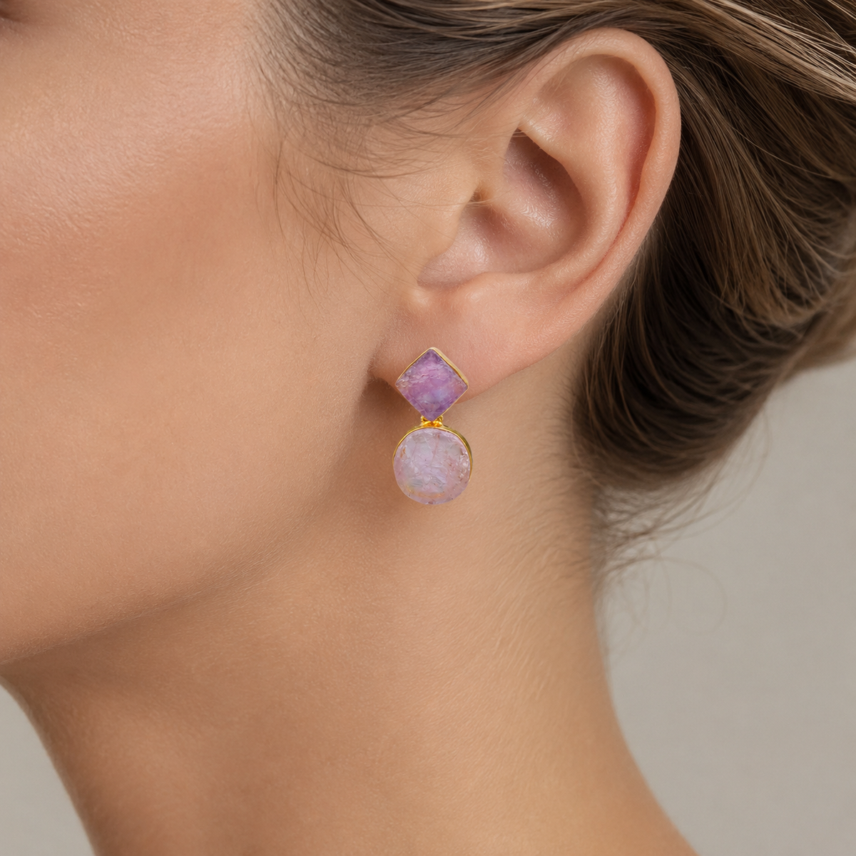 Pair of gold-plated drop earrings with rough amethyst stones shown front view.