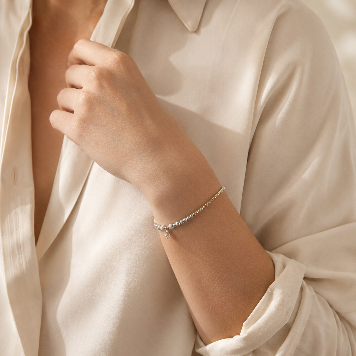 A bracelet with shiny bead accents and a petite heart pendant.