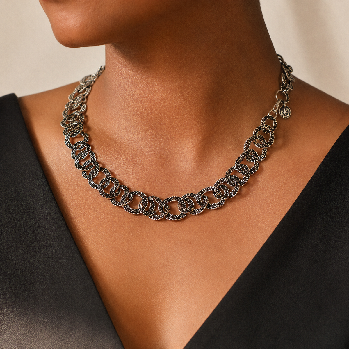 Textured silver oval link necklace shown on a white background.