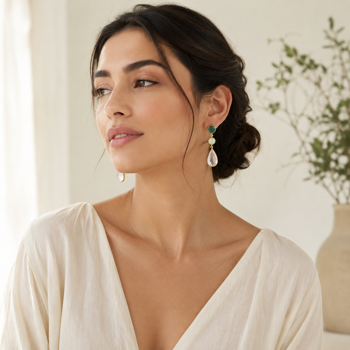 Pair of gold-plated drop earrings with green and clear stone details.