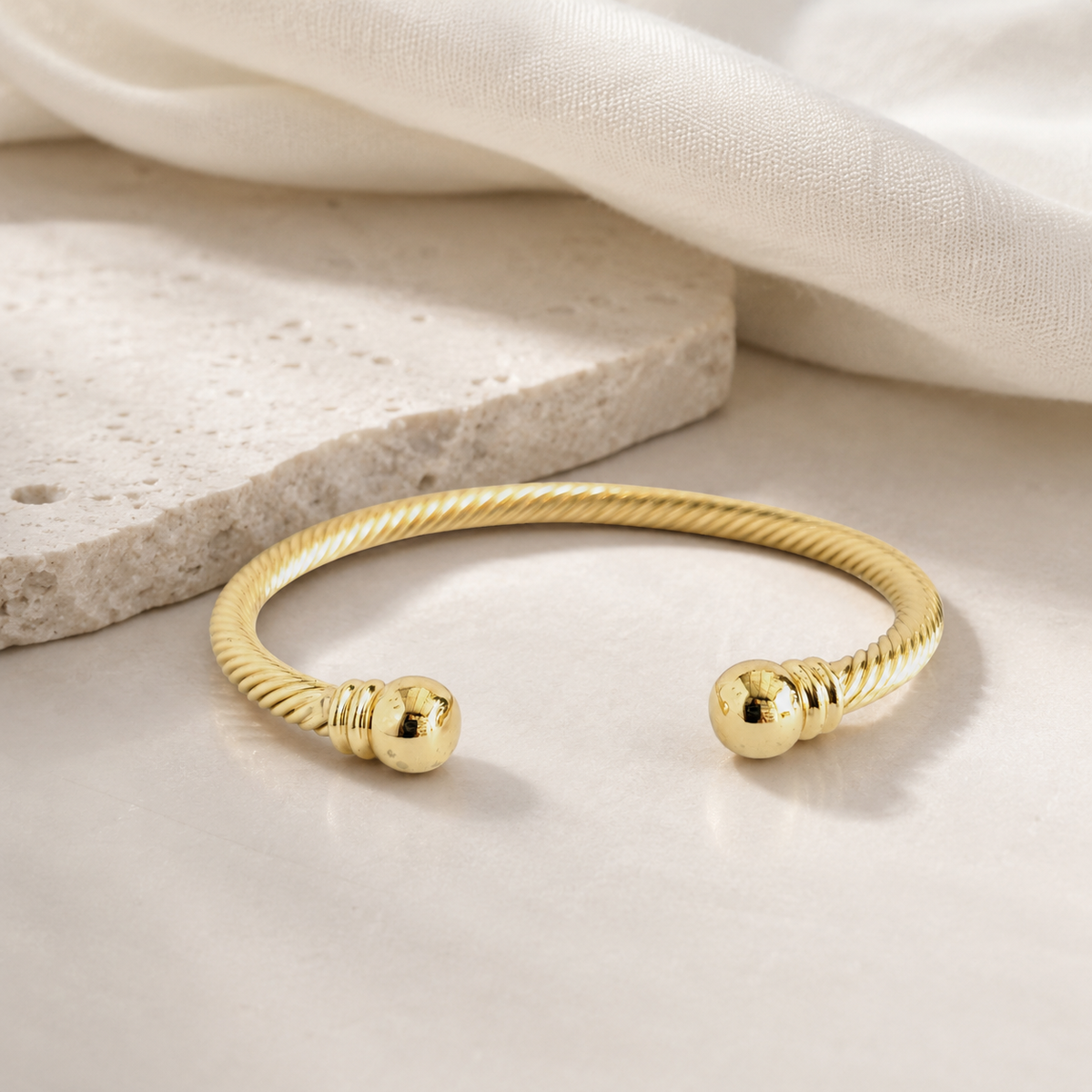 Minimalist gold-tone cuff bracelet with a sculptural shape.