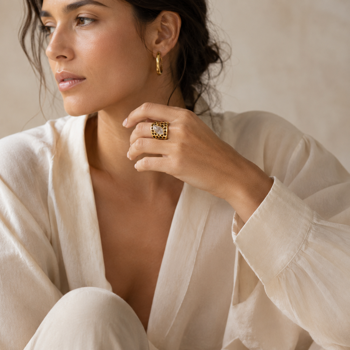 Gold-plated ring featuring a clear quartz center and open circular detailing.