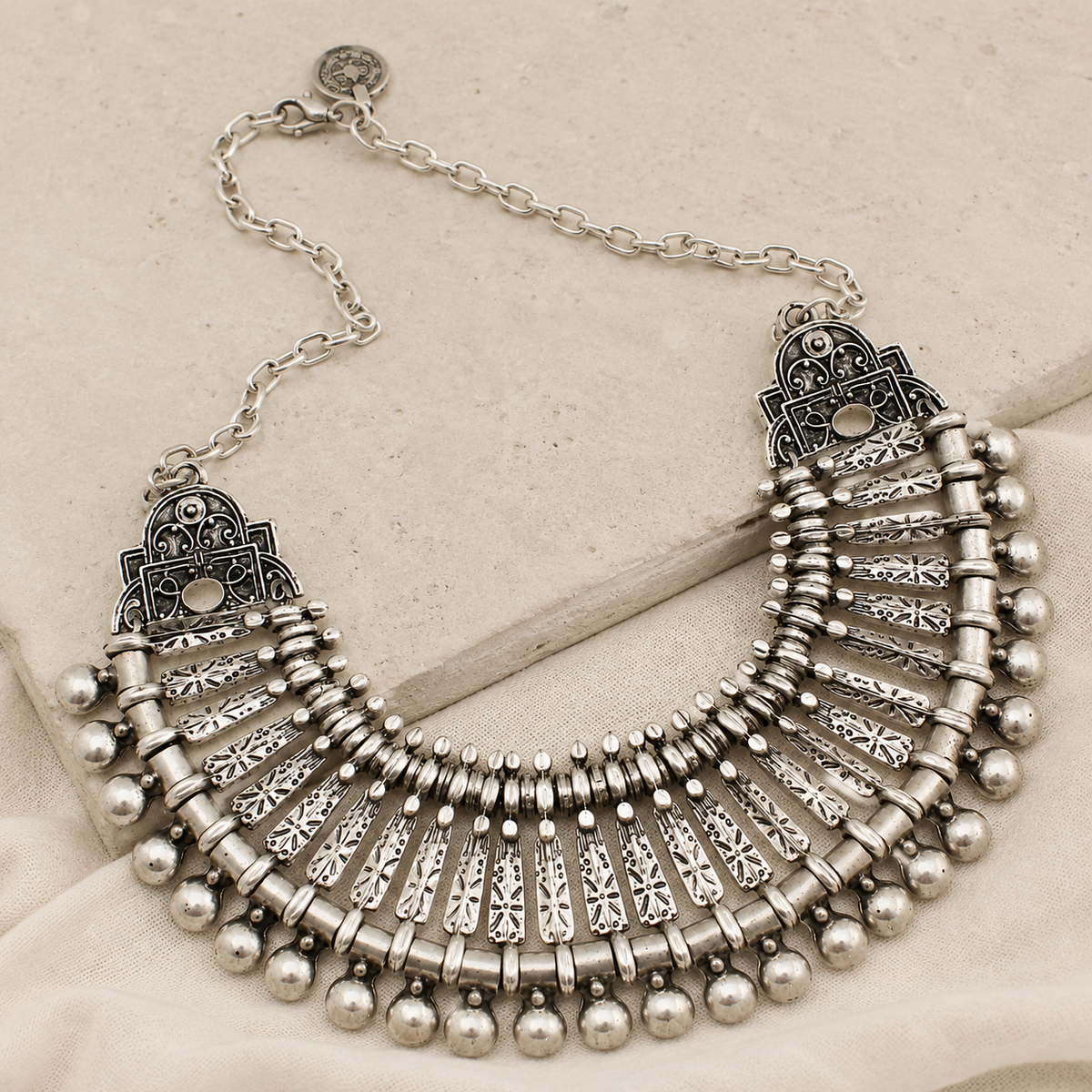 Angled view of a silver-tone boho fan collar necklace with layered detailing.