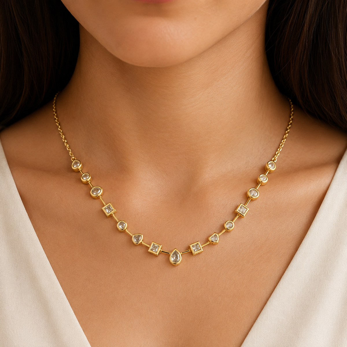 Gold-tone mixed shape gemstone station necklace shown front view.