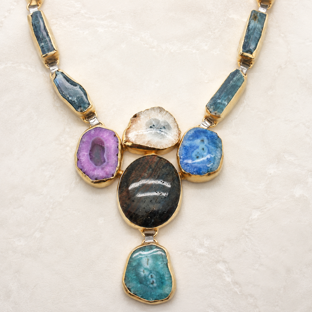 Close view of the necklace’s colorful stone details and gold-tone setting.