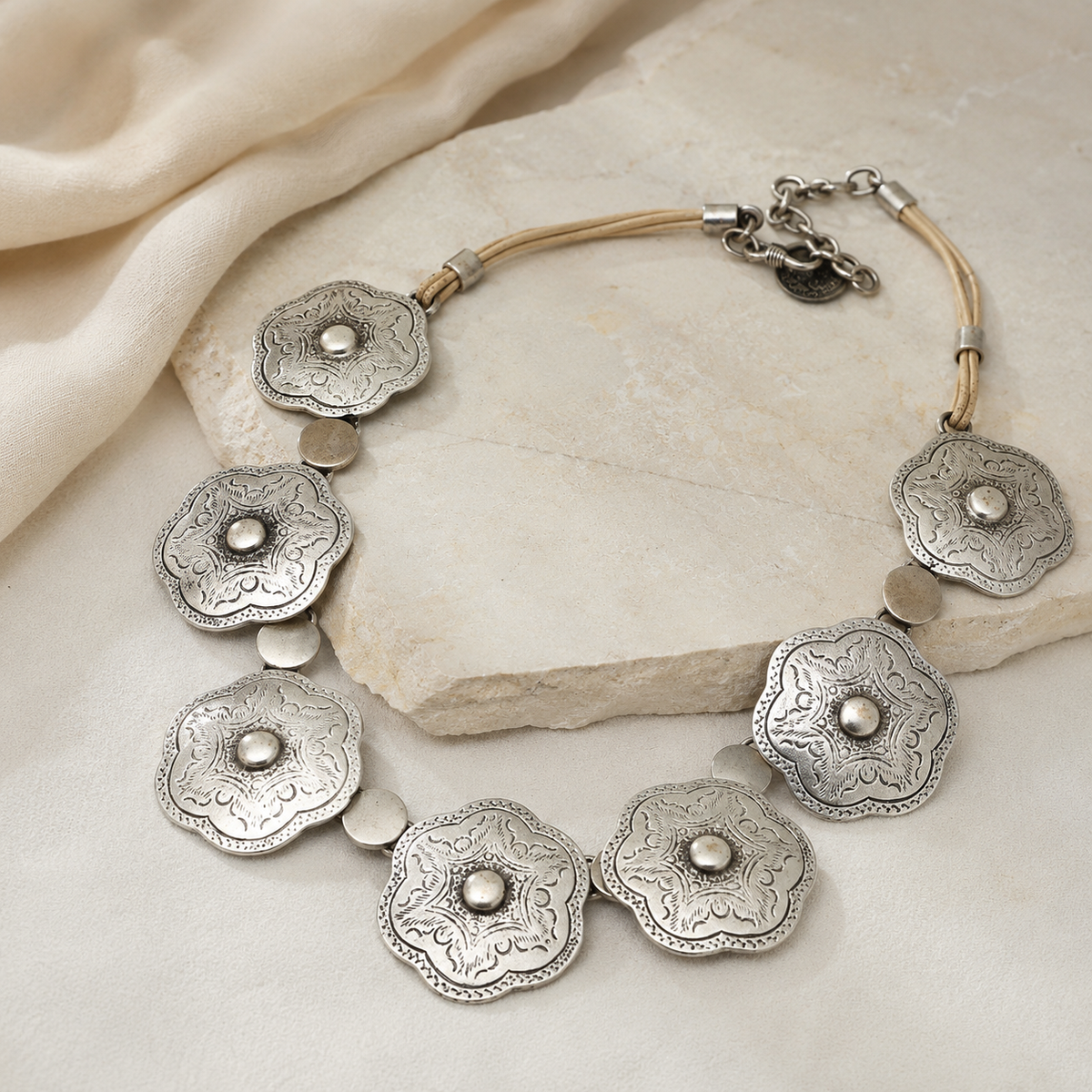 Silver floral plate necklace shown in a clean product view on a white background.