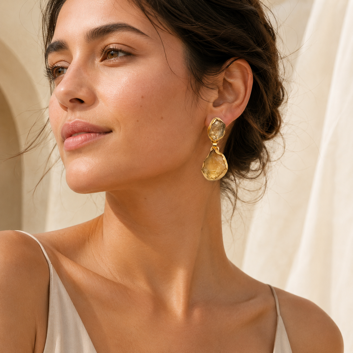 Gold-plated drop earrings with rough citrine-like stones in a detailed product view.