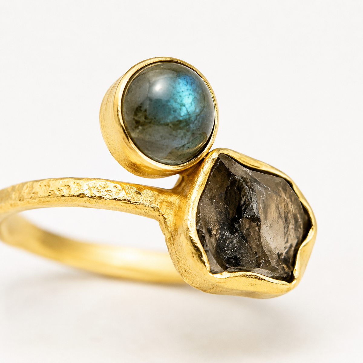 Close view of the ring showing the textured gold-plated band and stone settings.
