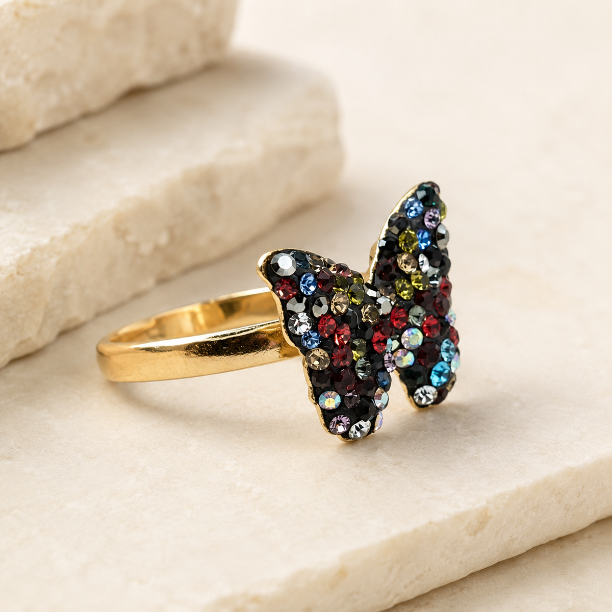 Angled view of a gold-plated butterfly ring with multicolor CZ stones.