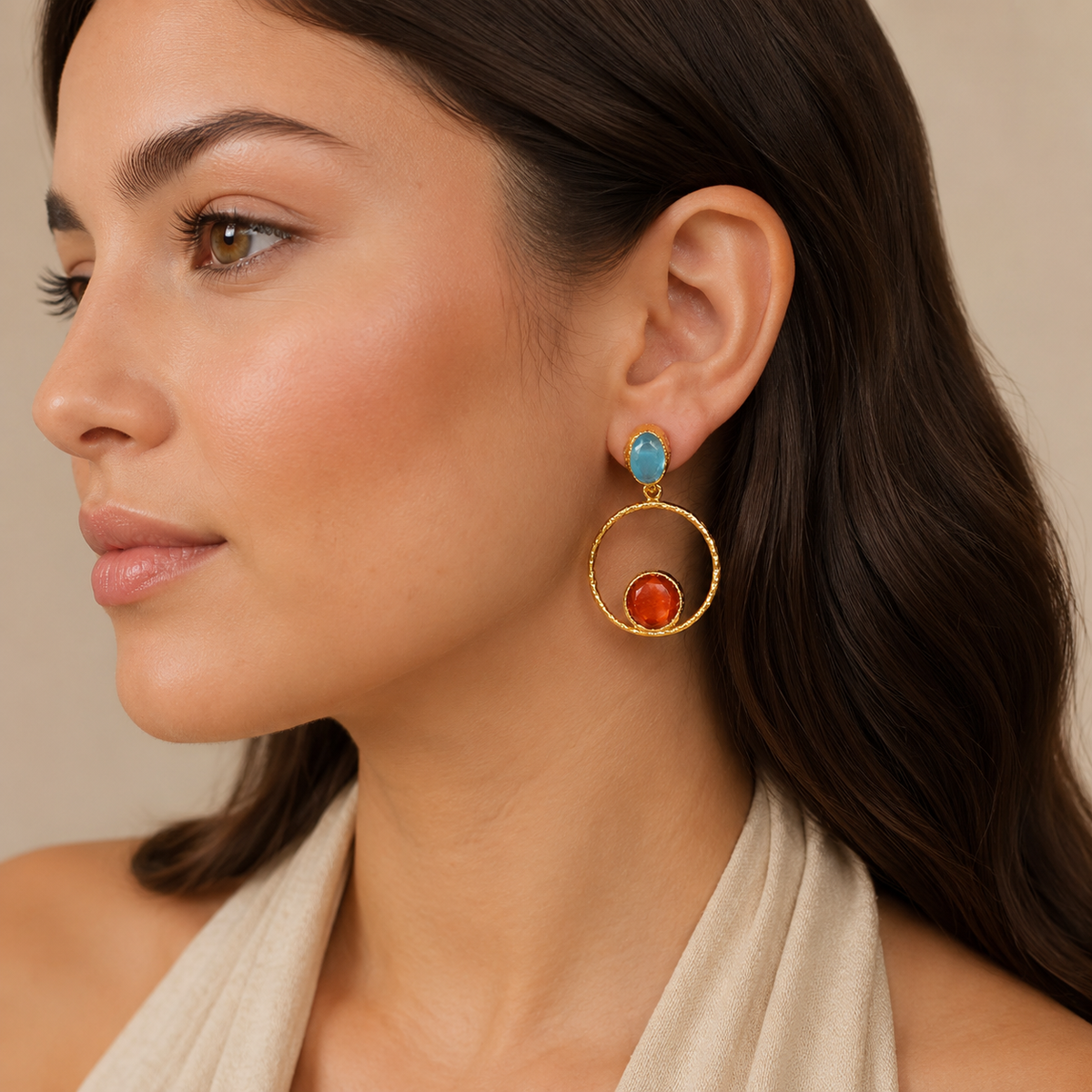 Gold-plated drop earrings with orange and teal accents shown from the front.