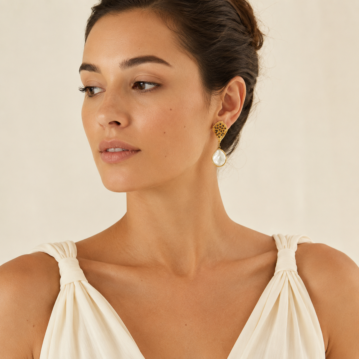 Pair of textured gold-tone earrings with black beads and pearl-like drops.