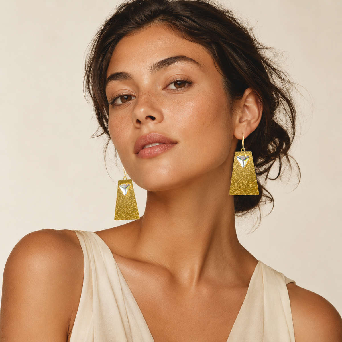 Gold geometric drop earrings with a clear crystal accent.