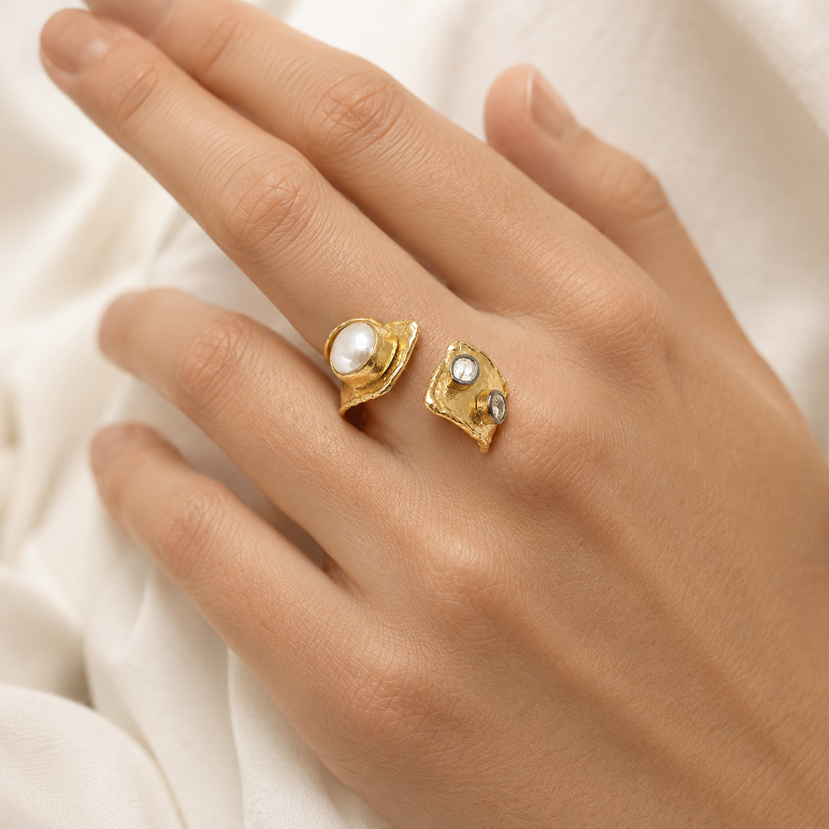 Close-up view of the open cuff ring showing the pearl-like detail and clear stones.