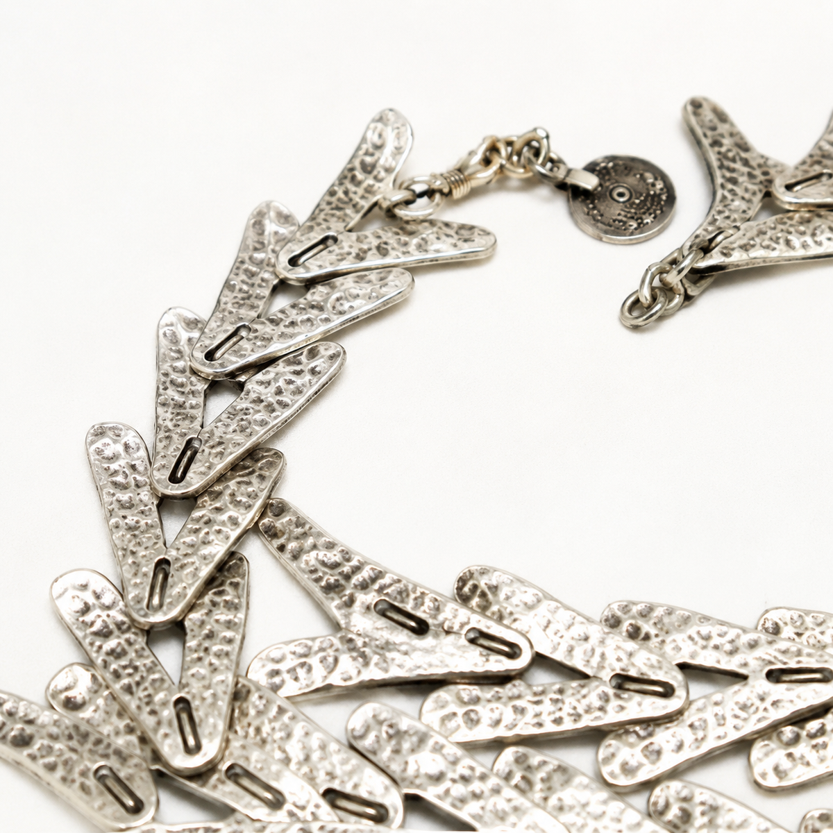 Close-up of textured silver-tone arrow links on the necklace.