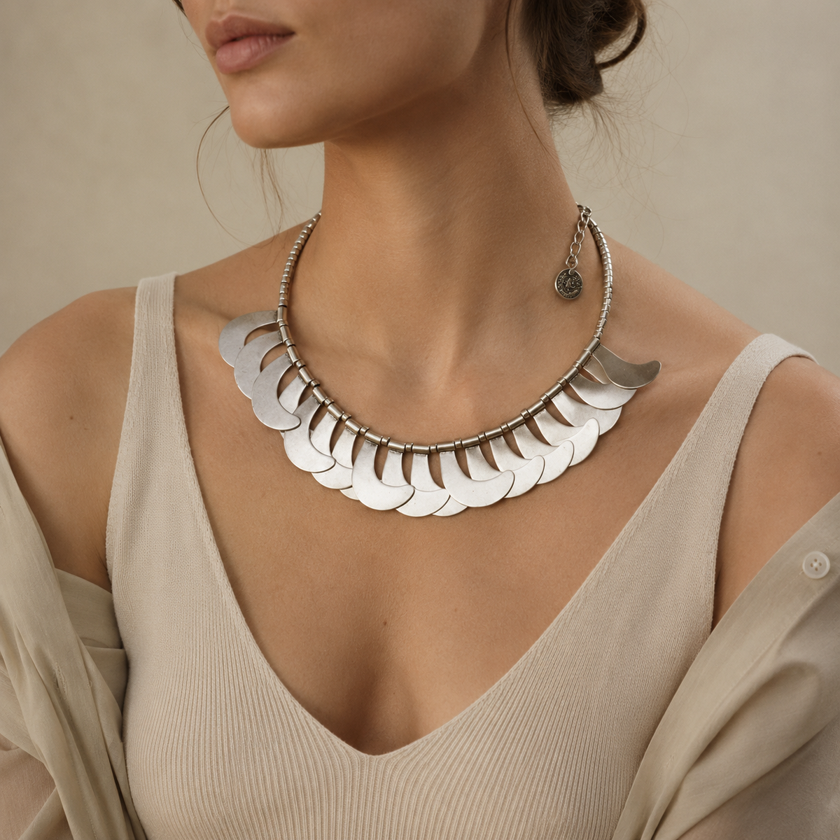 Silver-tone crescent scale necklace with a bold collar silhouette.