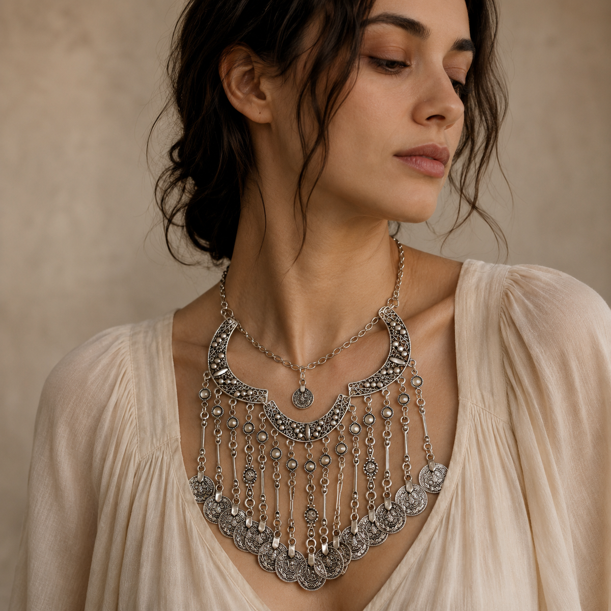 Silver-tone crescent necklace with ornate coin fringe accents.
