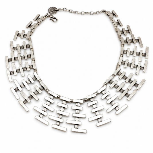 Silver-tone collar necklace with layered bar fringe and a sculptural shape.