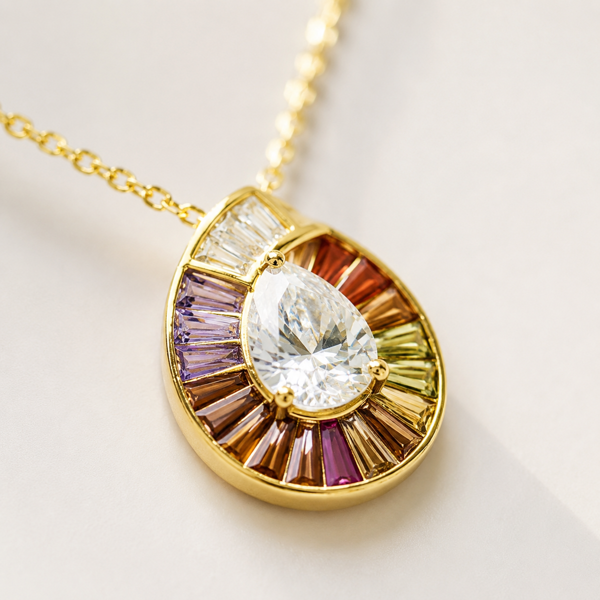 Close view of the teardrop pendant with clear center stone and rainbow accents.