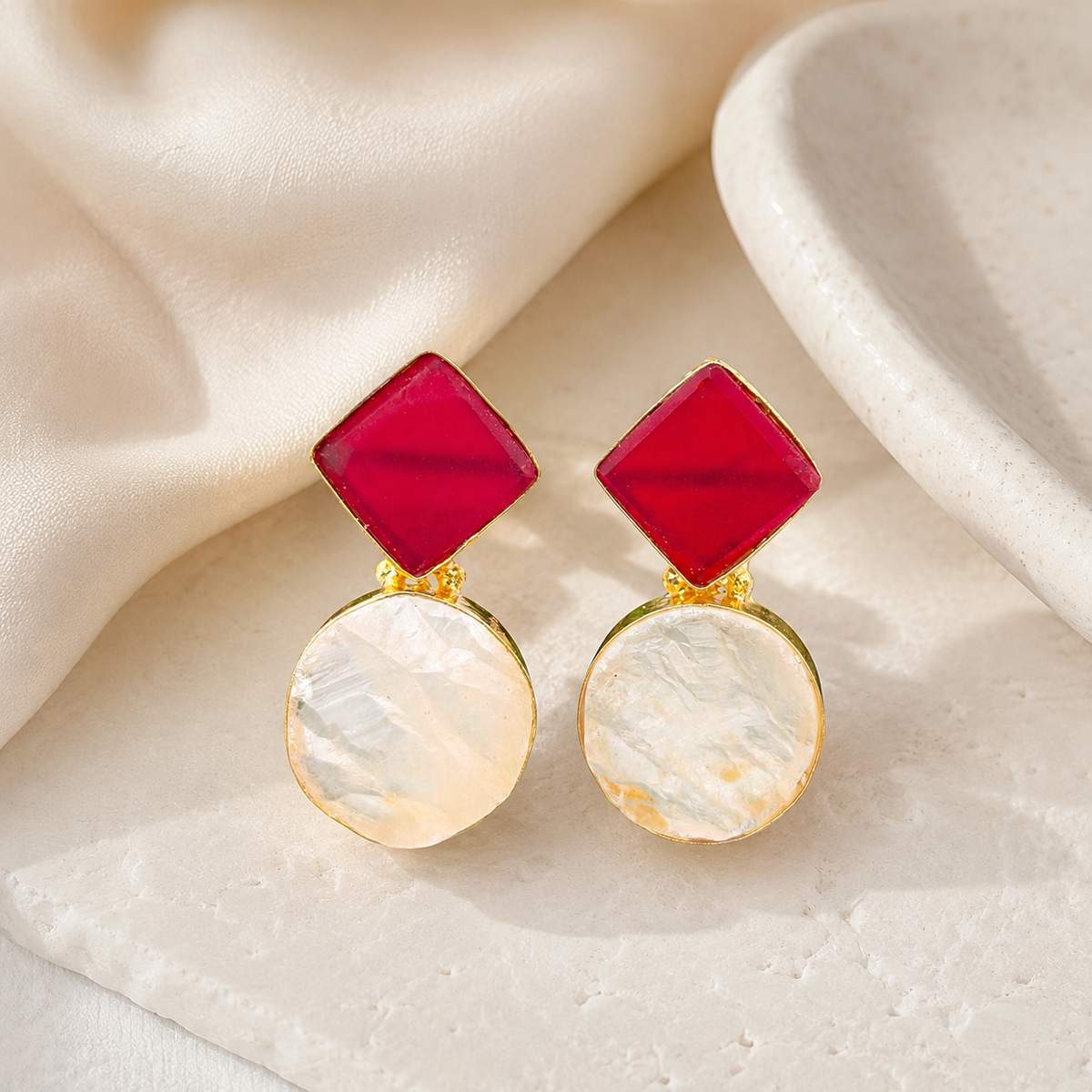 Gold-plated earrings with a bold red top and pale round drop detail.