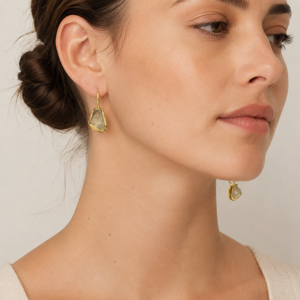 Raw amethyst drop earrings with a gold-plated setting shown from the front.