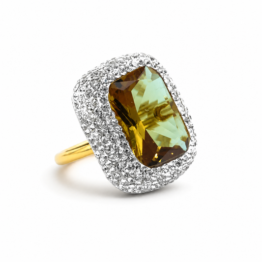 Rectangular faceted center stone ring with a sparkling halo and gold-tone band.