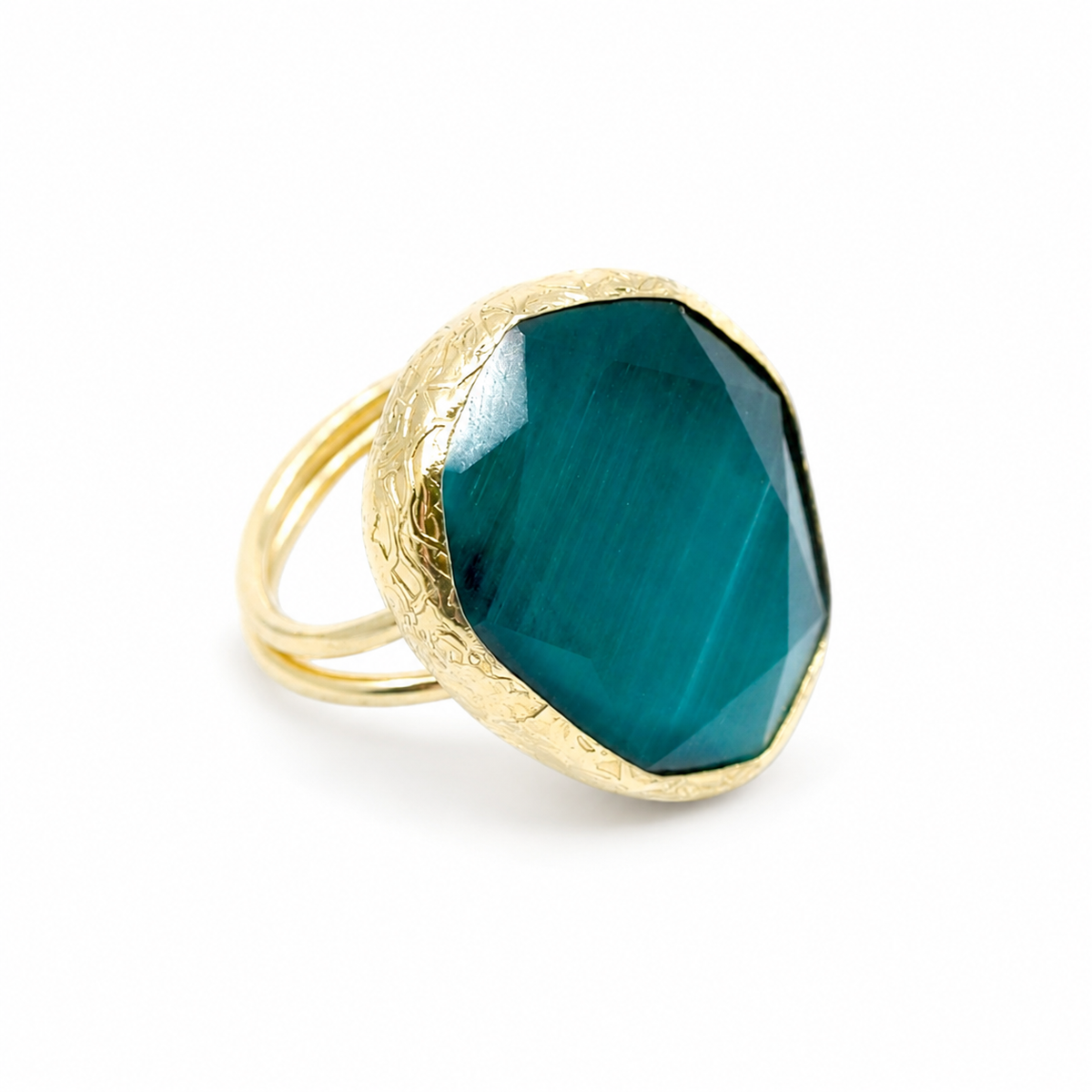 Gold-tone ring with a faceted green cat eye stone and textured setting.