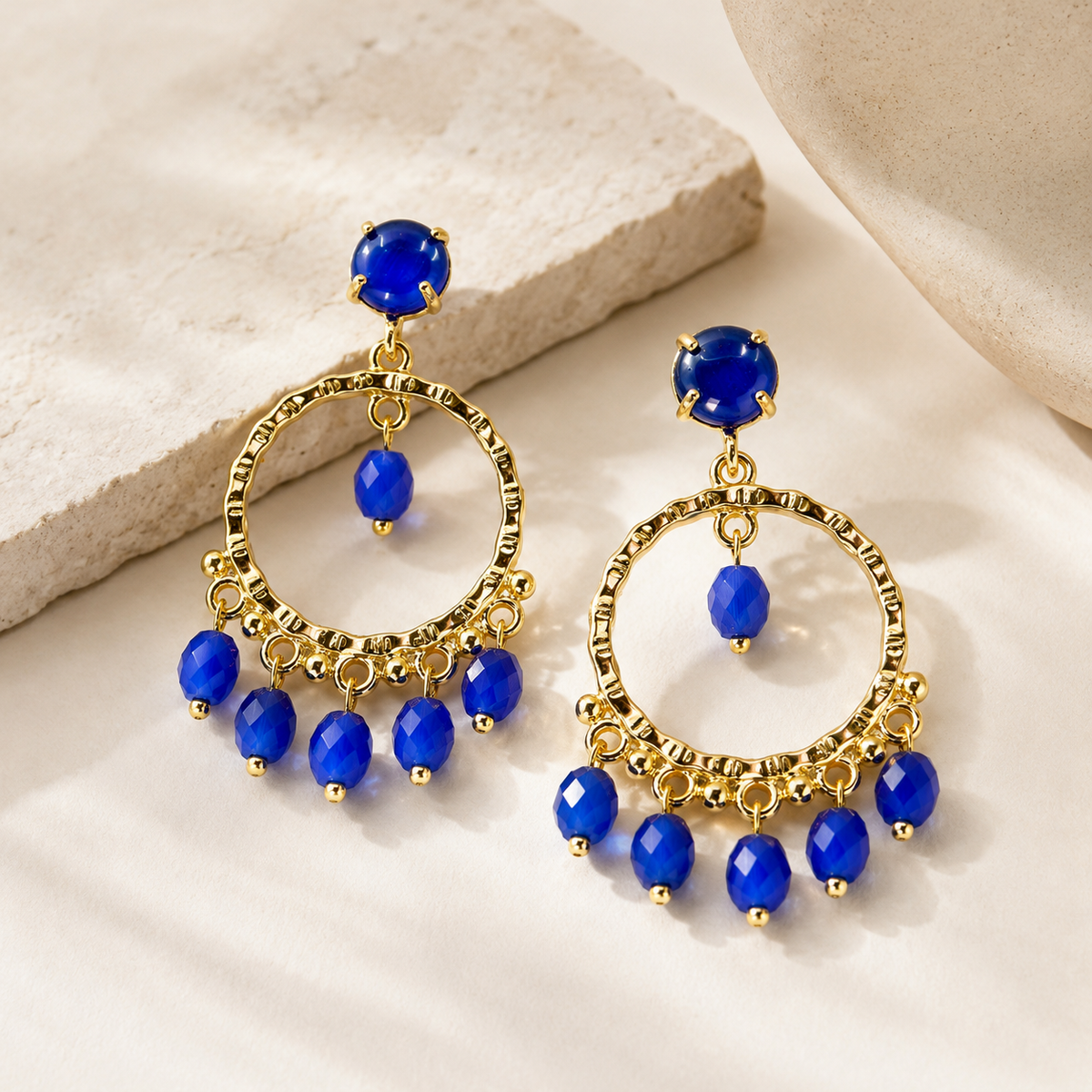 Gold-plated earrings with blue stones and a layered dangle design.