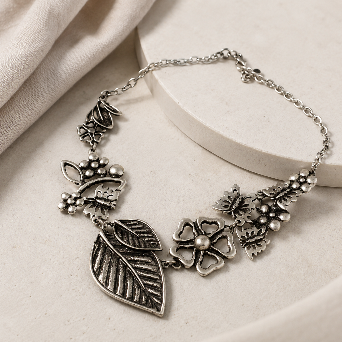 Angled view of a silver-tone floral leaf statement necklace.