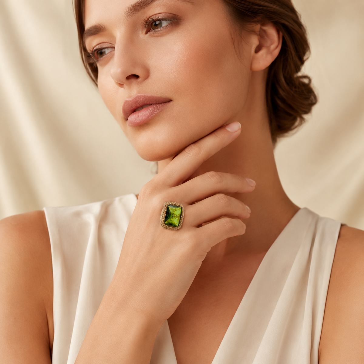 The ring is shown from the front with a faceted green stone and detailed frame.