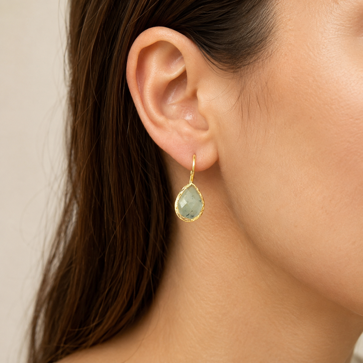 Pair of gold-plated teardrop earrings with faceted green stones.