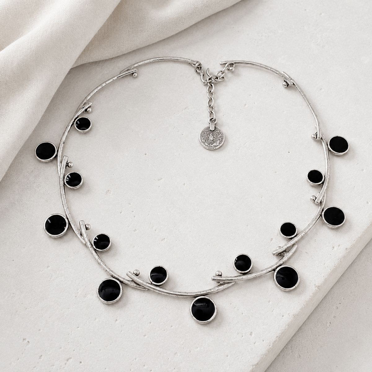 Silver-tone open collar necklace with black stones in a clean studio view.