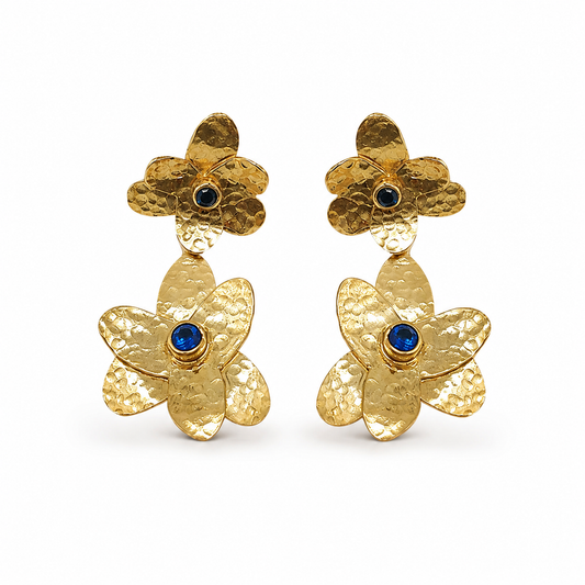 Gold-plated double flower drop earrings with blue stone centers on a white background.