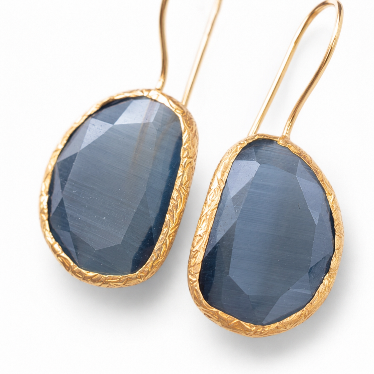 Close view of gray stone teardrop earrings with a gold-plated frame.