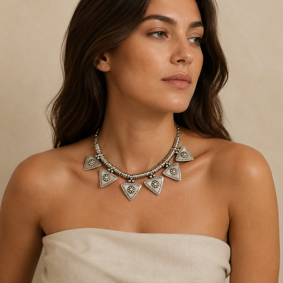 Silver-tone triangle flower charm necklace with sculptural links and pendant details.