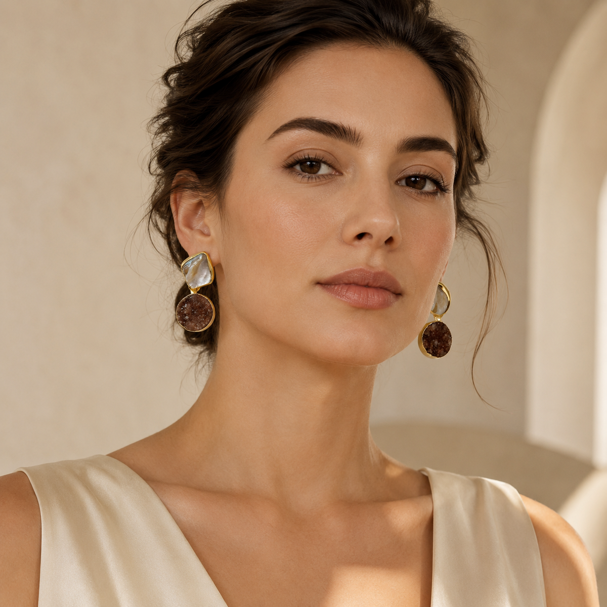 Gold-plated earrings with mixed black and neutral stone-like details.