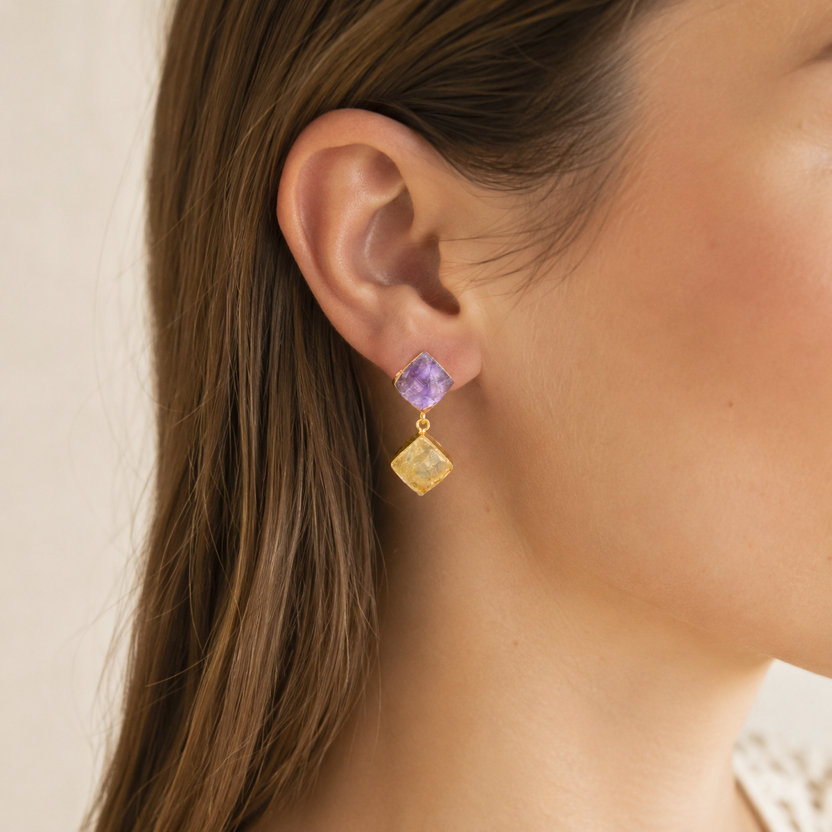 Gold-plated drop earrings with rough-cut purple and yellow stones.