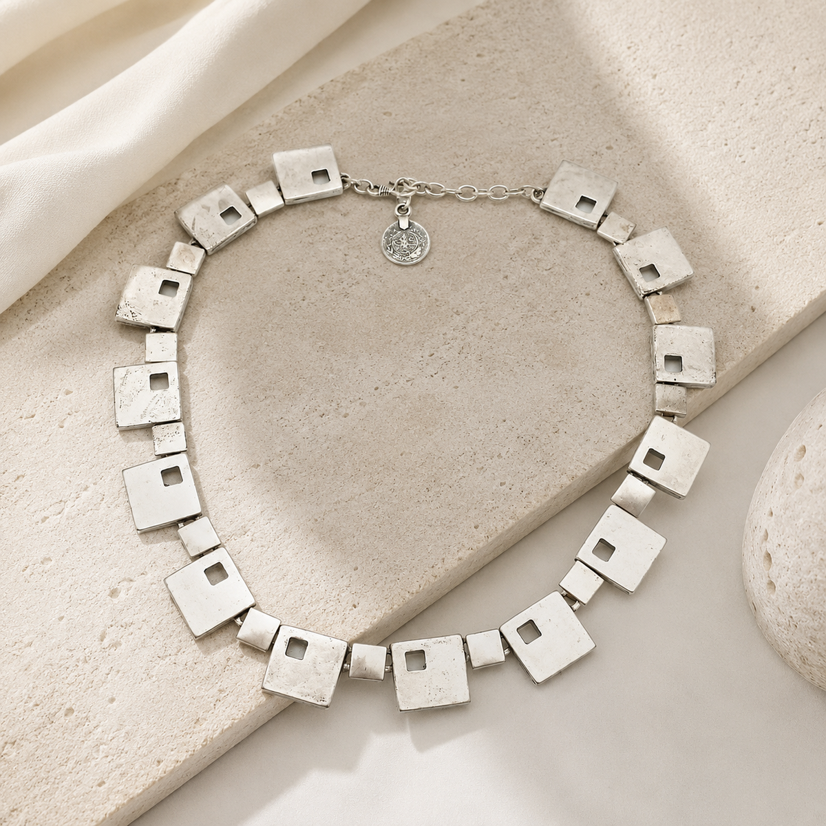Geometric square necklace styled in a clean, modern silhouette.