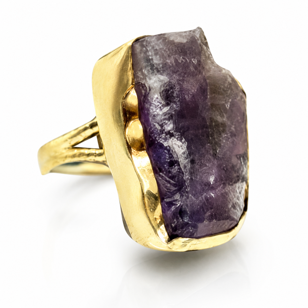 Close-up of a raw amethyst stone set in a gold-plated ring.
