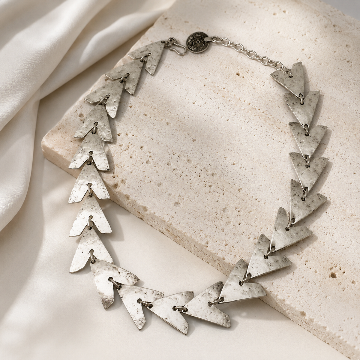 Triangle link necklace with a sculptural silver-tone look.