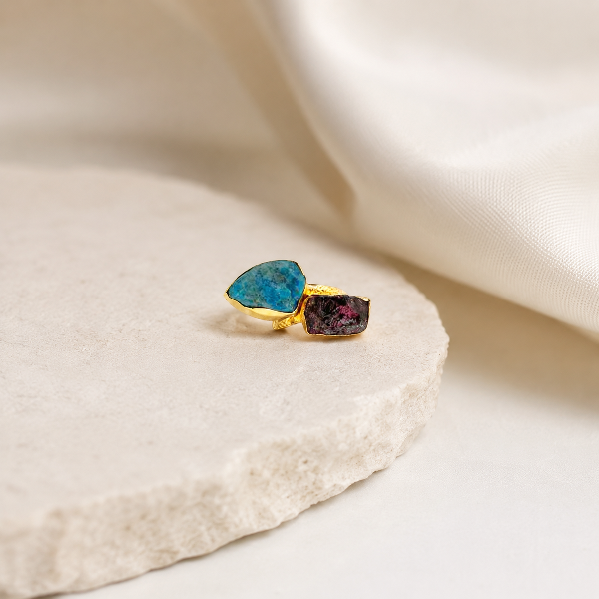 Gold-plated ring with raw blue and dark red stones styled for a modern look.
