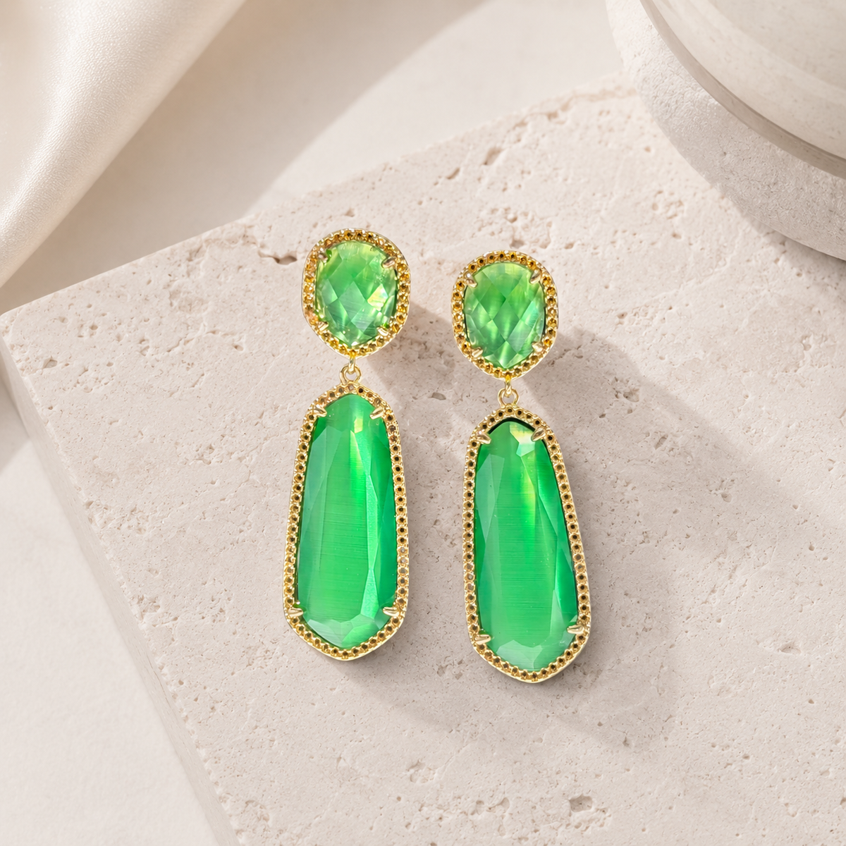 Gold-plated earrings with bright emerald green stones and a drop silhouette.