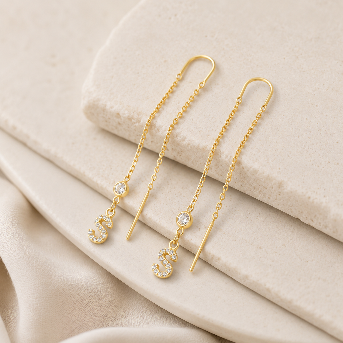 Personalized gold-tone earrings with a sparkling initial charm.