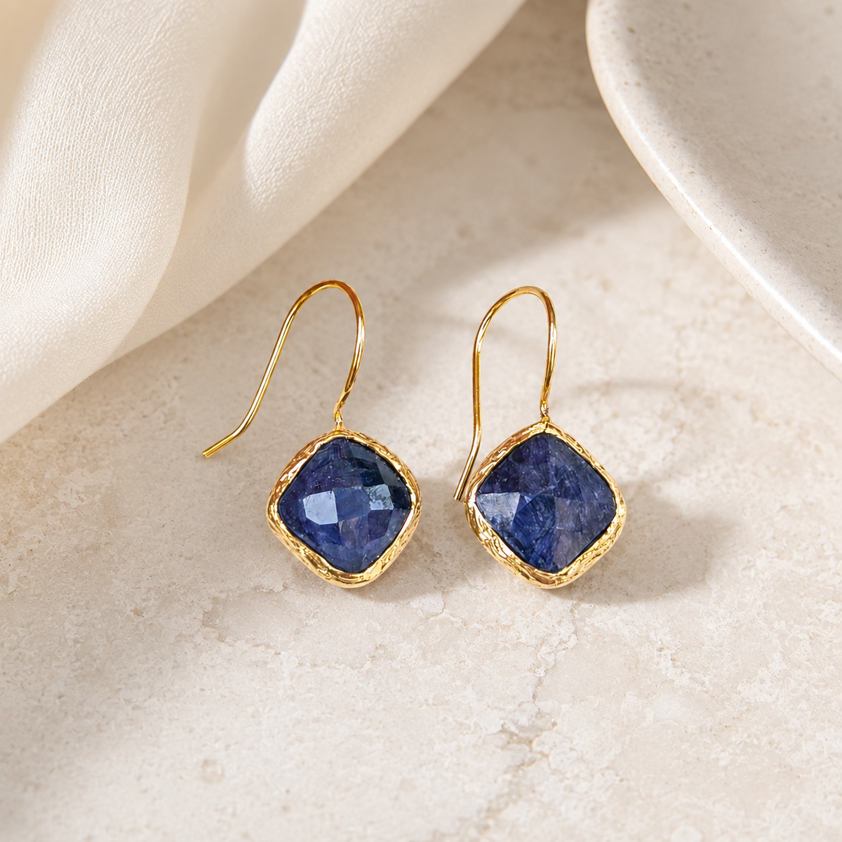 Blue sapphire gold-plated dangle earrings with a polished finish.