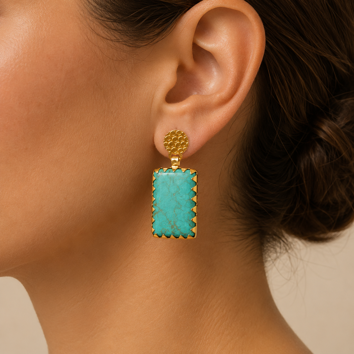 Pair of turquoise square drop earrings with gold-plated framing on a white background.