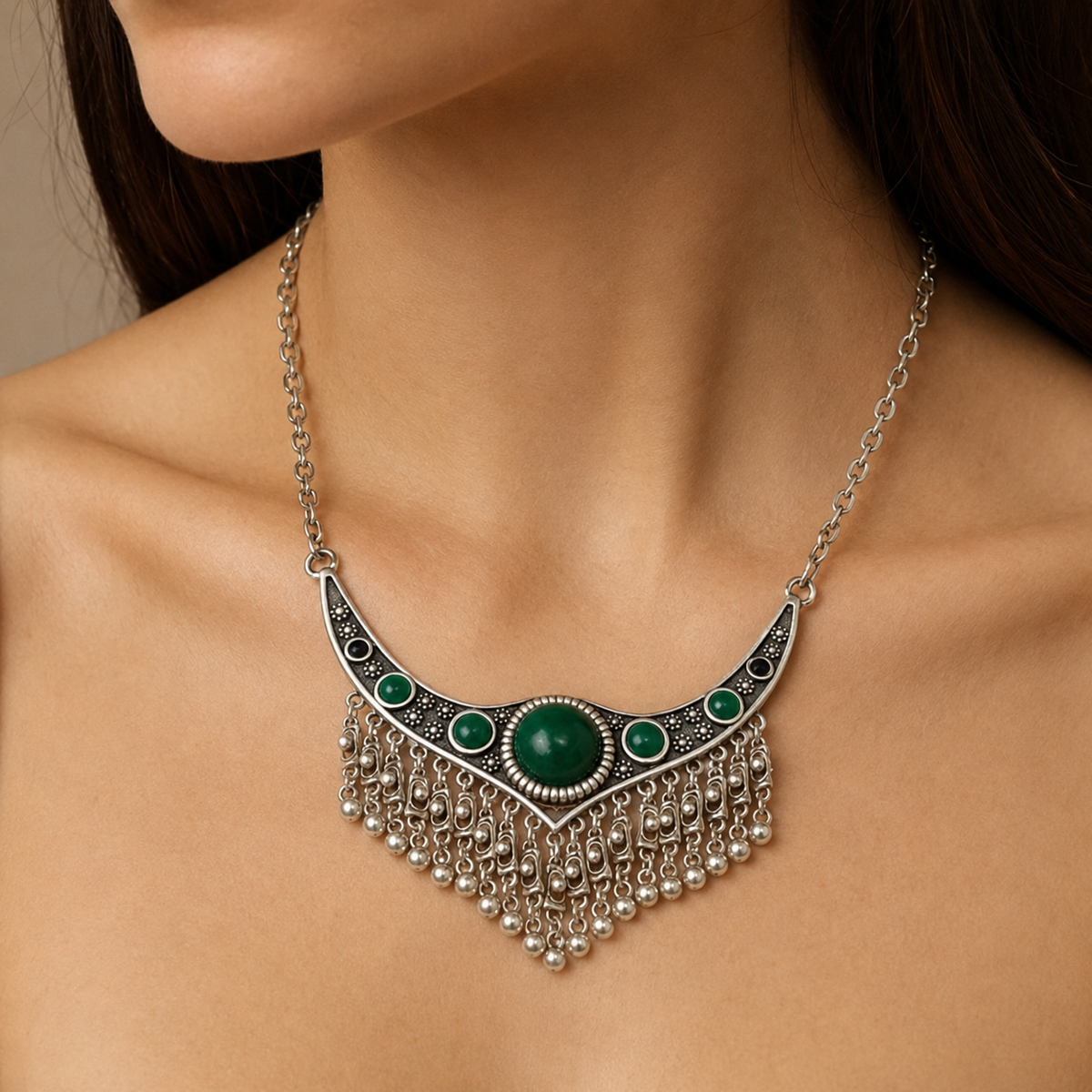 Silver-tone necklace with a green stone center and chain fringe.